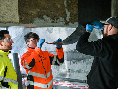 Eksperterne påfører det første lag kulfiberstof til forskydningsarmeringen.
